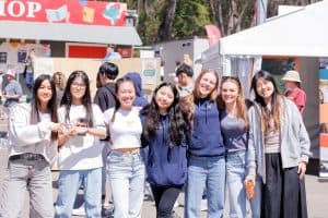 Group of diverse teenagers smiling at KyCK 2026 event in Australia, part of youth church conference, showcasing community and faith engagement in outdoor festival setting.