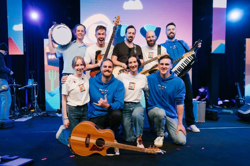 Group of young musicians performing on stage at KYCK 2026 youth event, playing various instruments including guitar, drums, and keyboard, with vibrant stage lighting.