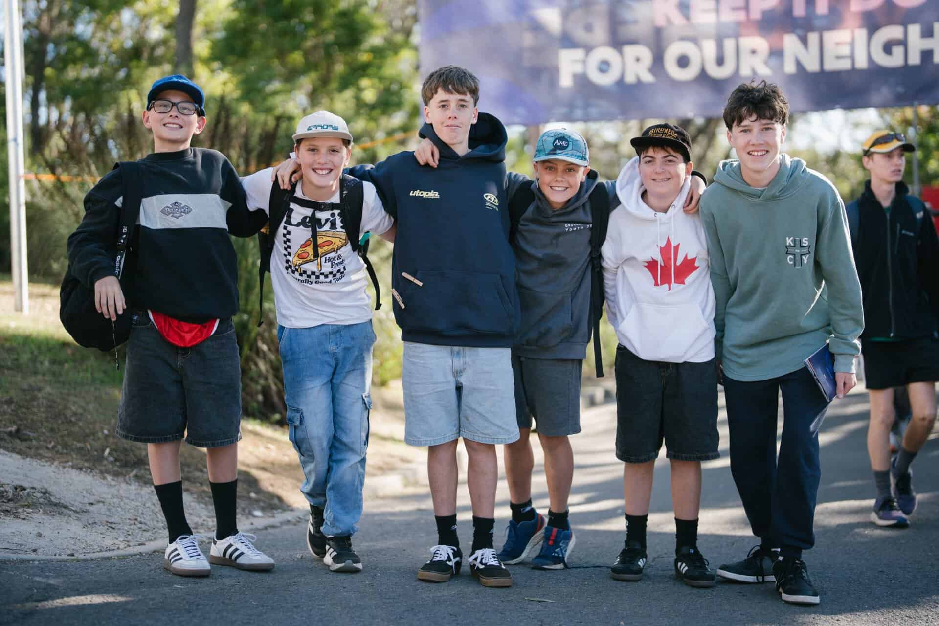 Group of diverse young teenagers smiling and walking together outdoors at KYCK 2026 youth camp event.
