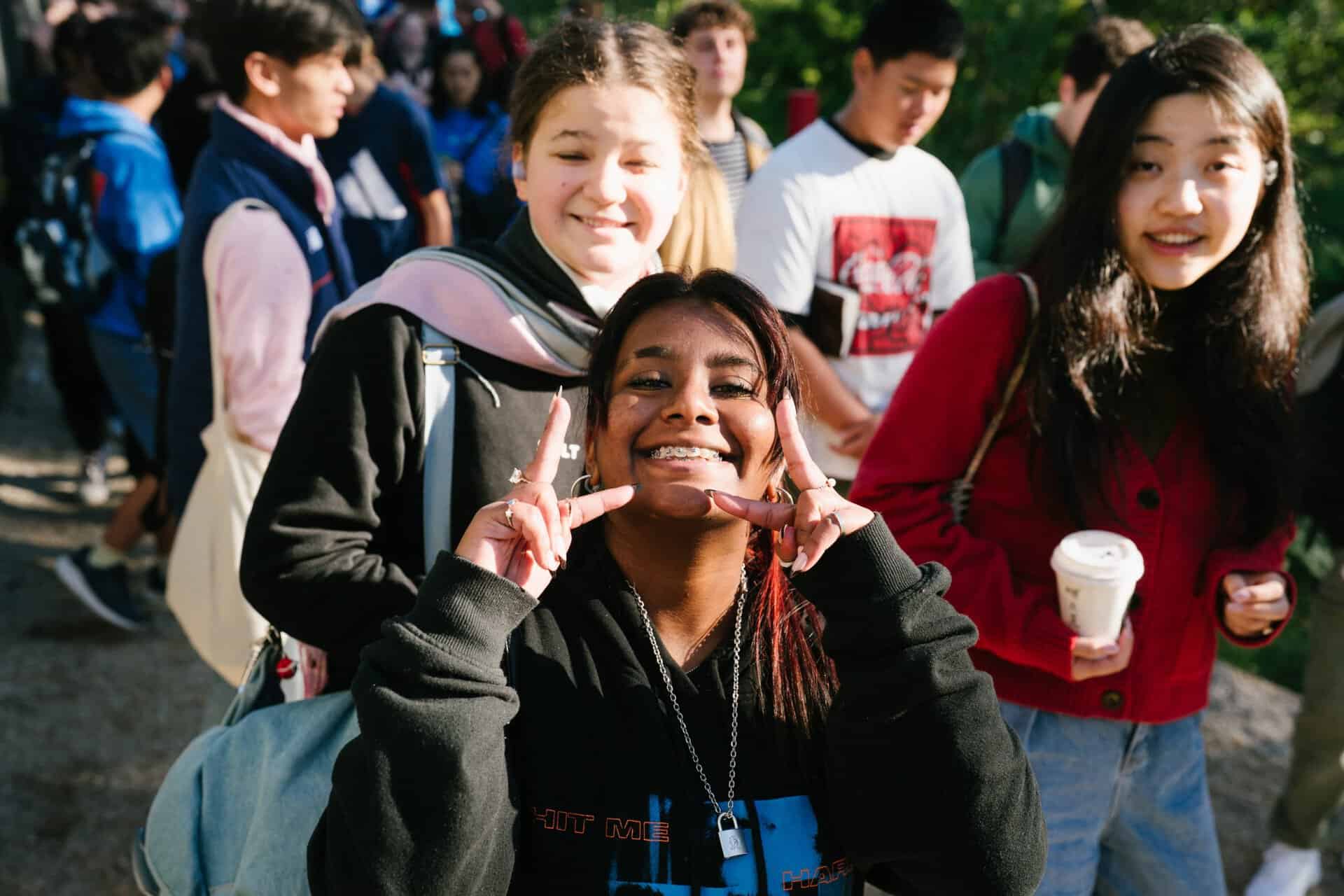 Group of diverse teenagers enjoying KYCK 2026 youth event outdoors, smiling and socialising, with some holding coffee cups, representing community and faith-based youth gathering.