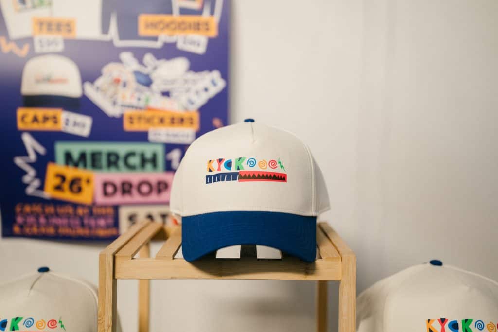 KYCK 2026 branded cap on display at the event, showcasing the upcoming youth conference with colourful logo and design.